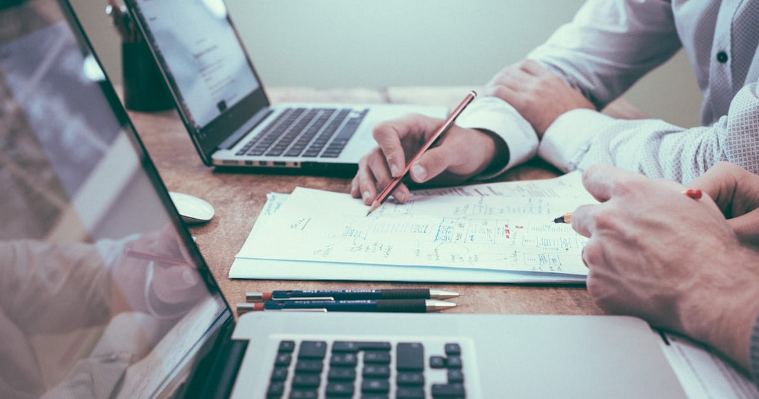 Excel spreadsheet with client data on a laptop screen