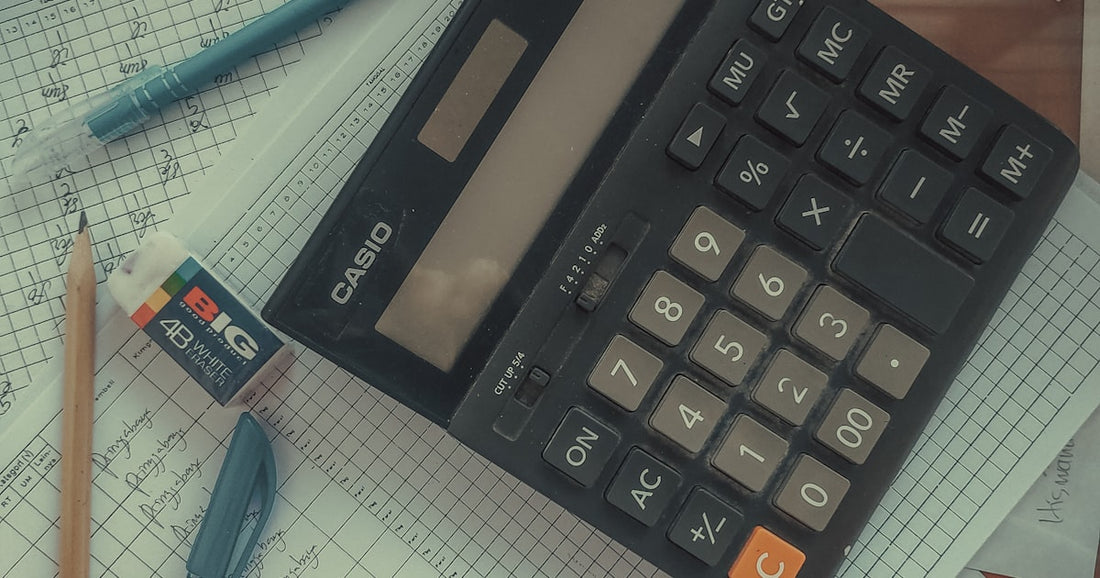 Calculator on a pile of paper bills - adding up what CRM subscriptions really cost